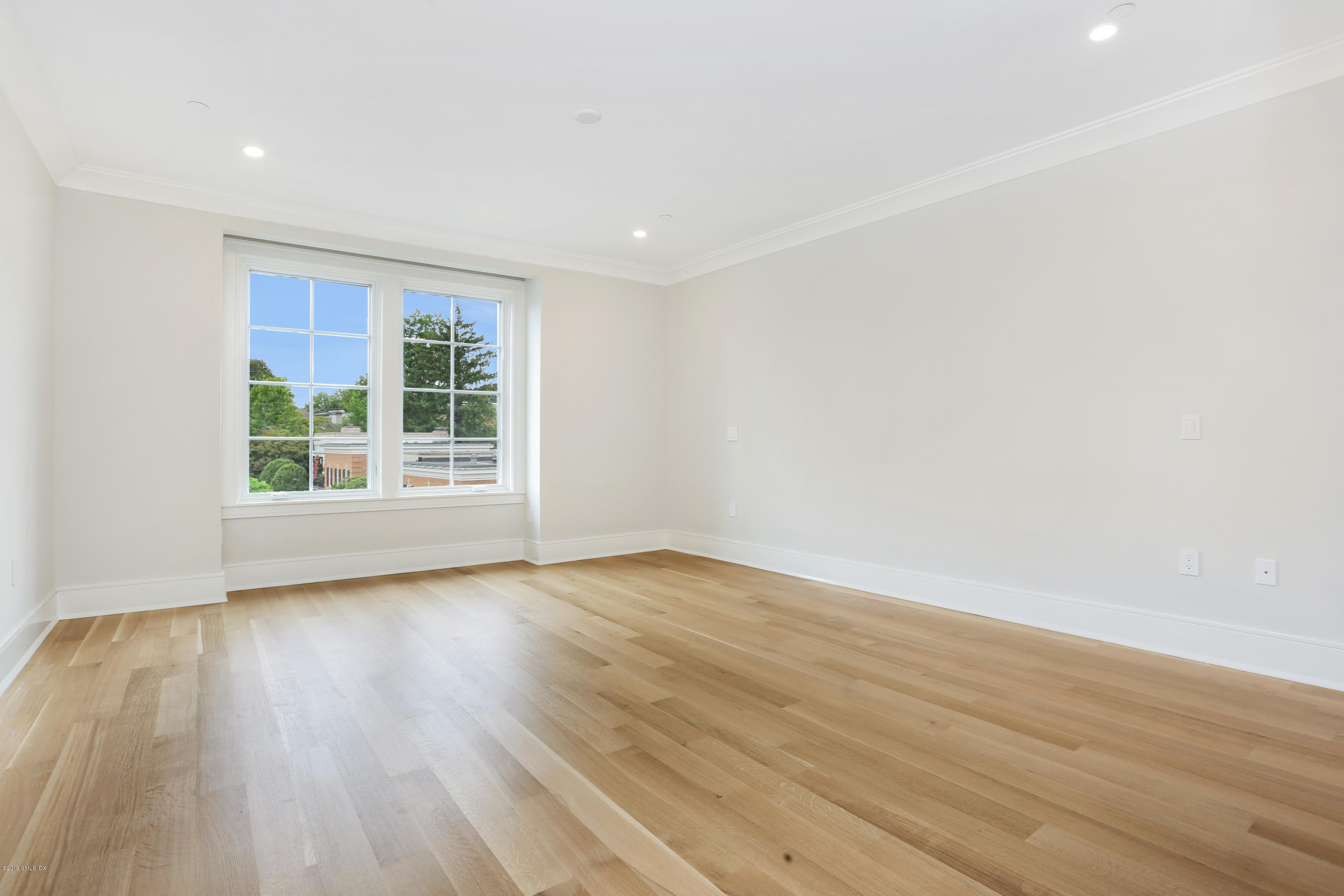 70 Sound View Drive, Unit PH WEST Greenwich, CT 06830 - Photo 9 of 16 a view of an empty room with wooden floor and windows