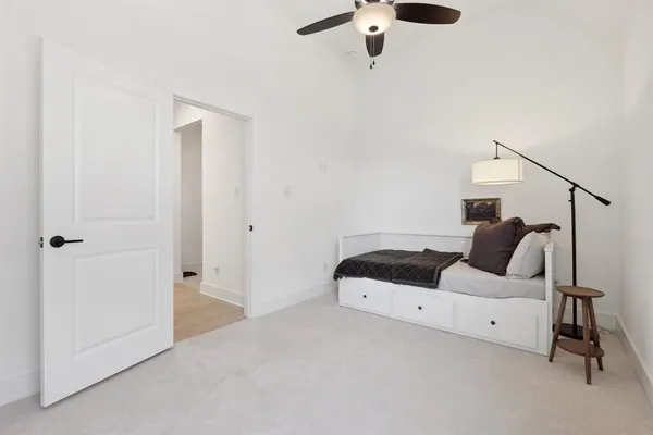a bedroom with a bed and a chandelier fan