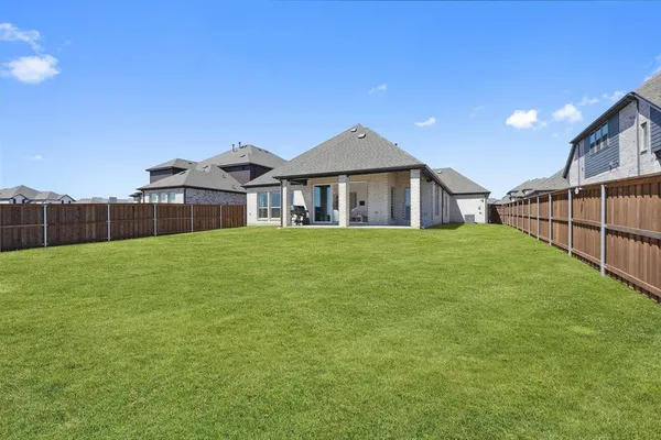 a view of a house with a big yard and large trees