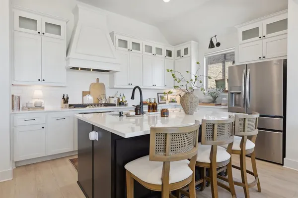 a kitchen with stainless steel appliances a sink and white cabinets