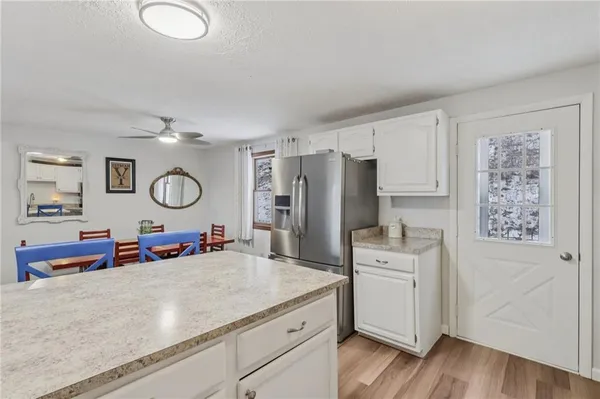 a kitchen with a refrigerator a stove top oven and a wooden floor