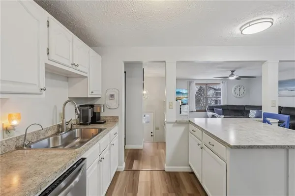 a kitchen with stainless steel appliances granite countertop a sink stove refrigerator and cabinets
