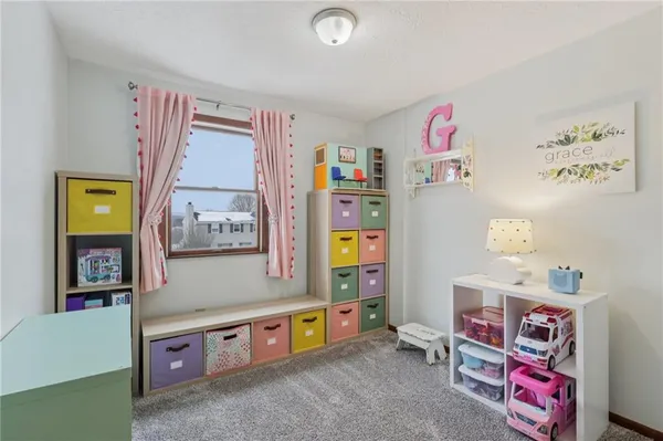 a living room with furniture and a baby crib