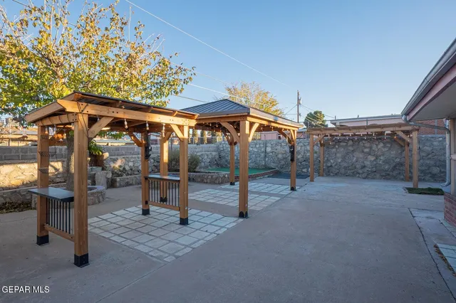 a view of a porch with a table and chairs under an umbrella