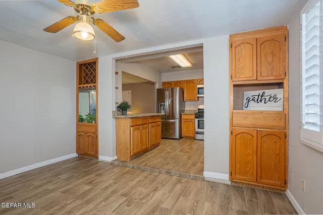 a view of a kitchen with wooden floor a sink a refrigerator and window