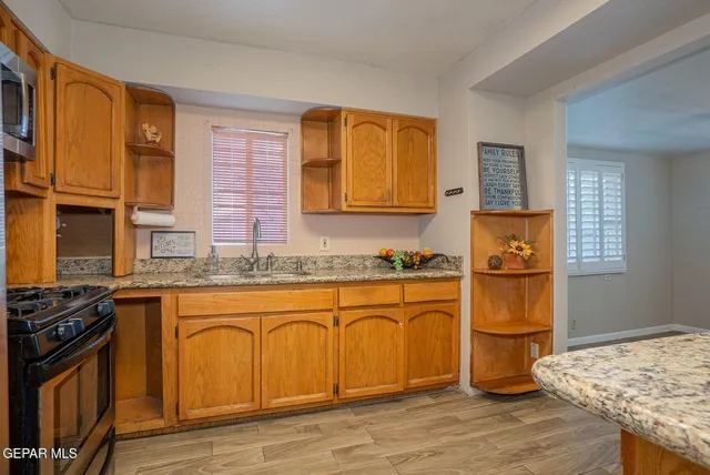 a kitchen with stainless steel appliances granite countertop a stove a sink dishwasher and a refrigerator