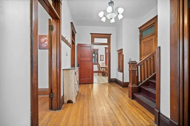 a view of a hallway with wooden floor and staircase