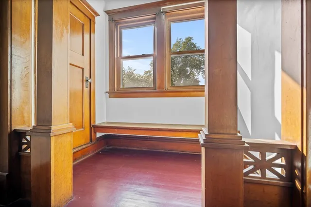 a view of a hallway with wooden floor and staircase