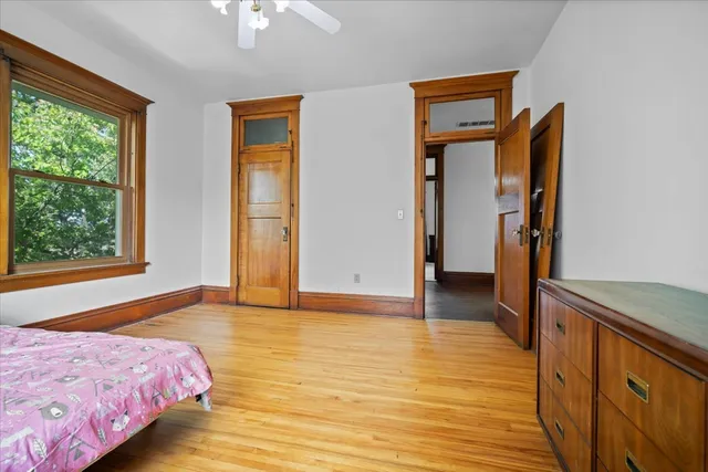 a bedroom with a bed wooden floor and window