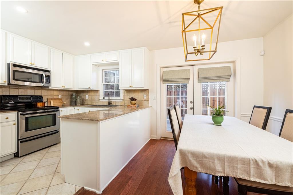 1101 Collier Road Northwest, Unit I3 Atlanta, GA 30318 - Photo 9 of 24 a kitchen with stainless steel appliances kitchen island granite countertop a stove a sink and a microwave