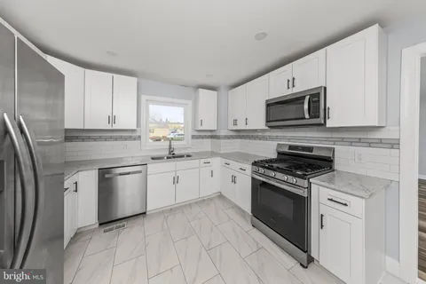 a kitchen with granite countertop cabinets stainless steel appliances and a counter space