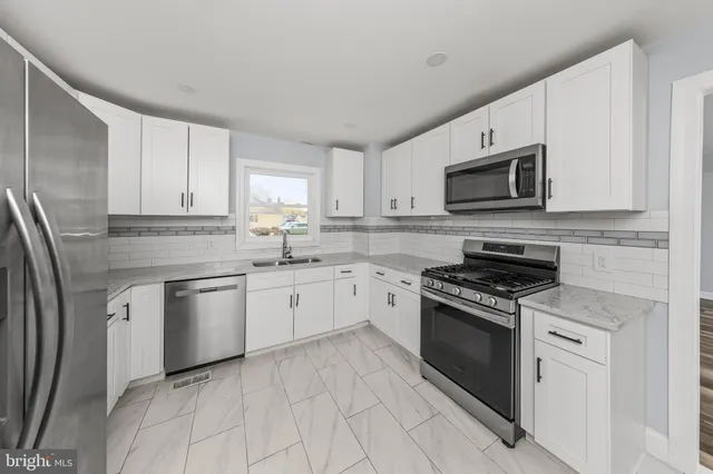 a kitchen with granite countertop cabinets stainless steel appliances and a counter space
