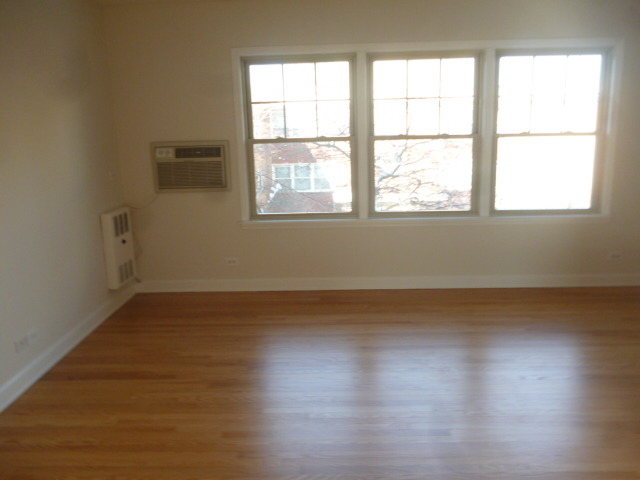 7530 North Ridge Boulevard, Unit 3W Chicago, IL 60645 - Photo 12 of 23 an empty room with wooden floor and windows