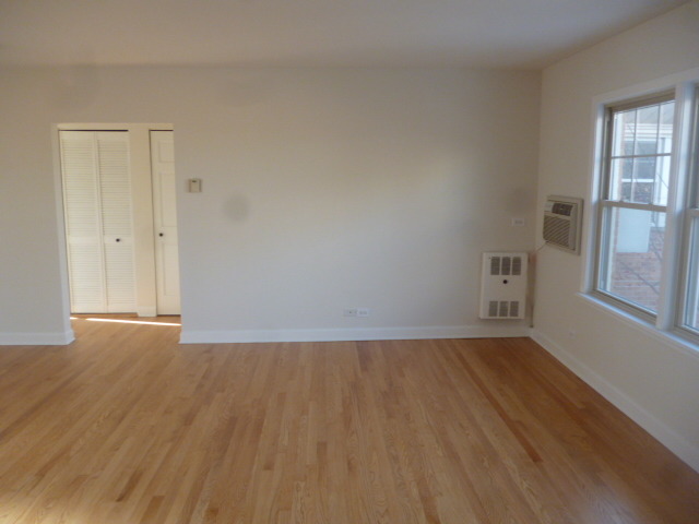 7530 North Ridge Boulevard, Unit 3W Chicago, IL 60645 - Photo 3 of 23 a view of an empty room with wooden floor and a window