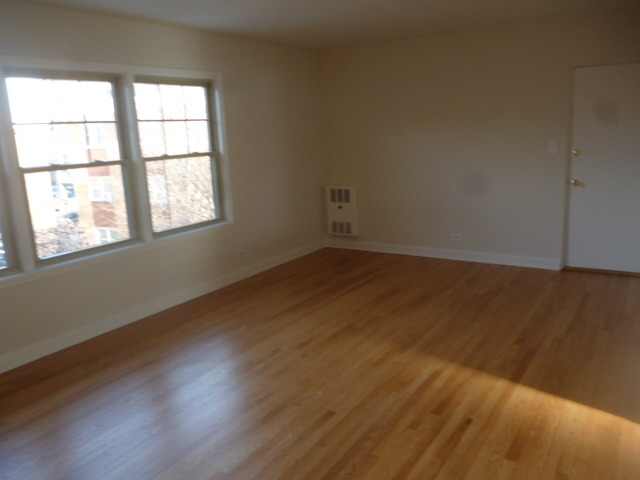 7530 North Ridge Boulevard, Unit 3W Chicago, IL 60645 - Photo 23 of 23 an empty room with wooden floor and windows