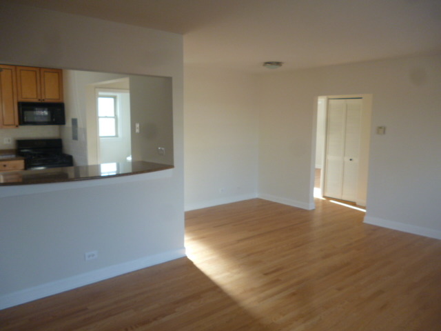 7530 North Ridge Boulevard, Unit 3W Chicago, IL 60645 - Photo 4 of 23 a view of empty room with wooden floor and fan