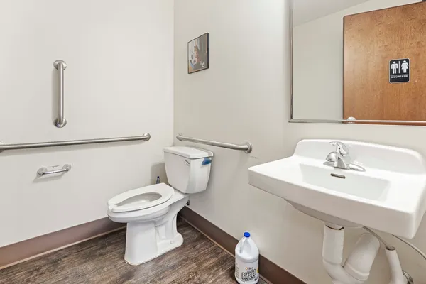 a bathroom with a sink toilet and a mirror