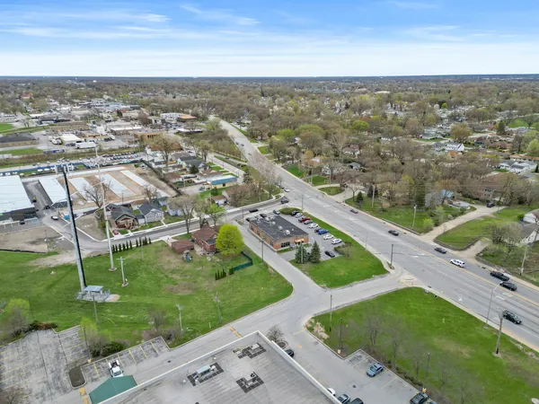 an aerial view of residential houses with outdoor space and trees
