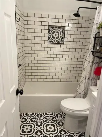 a bathroom with a toilet and a shower