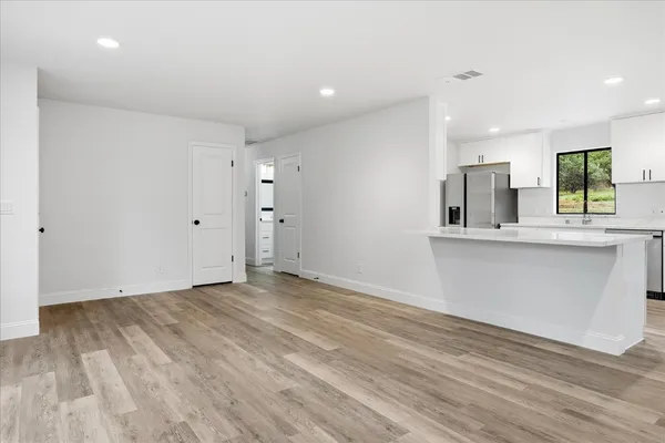 an empty room with wooden floor and windows