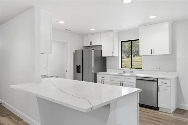 a kitchen with stainless steel appliances a refrigerator sink and cabinets