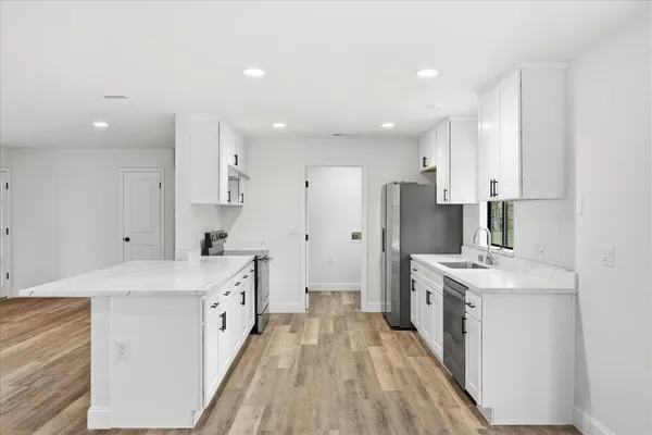 a kitchen with stainless steel appliances sink stove refrigerator and cabinets