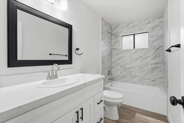 a bathroom with a sink a toilet and shower a mirror