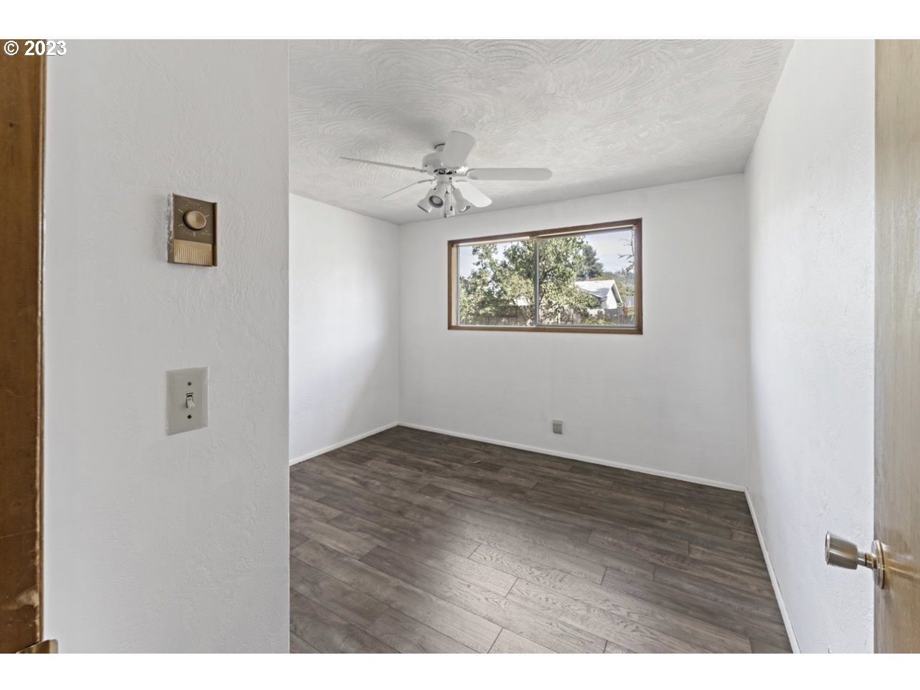 2747 32nd Street Springfield, OR 97477 - Photo 12 of 17 a view of an empty room with wooden floor and a ceiling fan