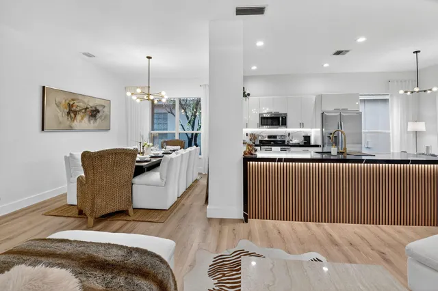 a view of a white house with a yard and a large tree