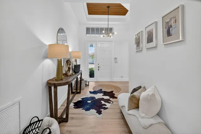 a living room with furniture chandelier and a large window