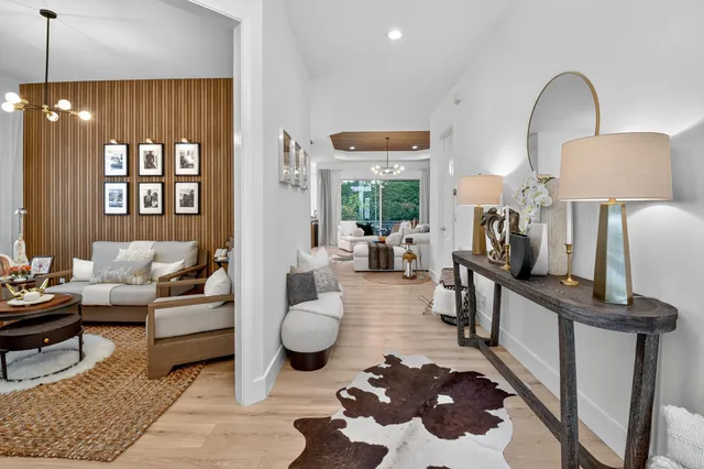 a kitchen with granite countertop a sink a stove cabinets and living room view