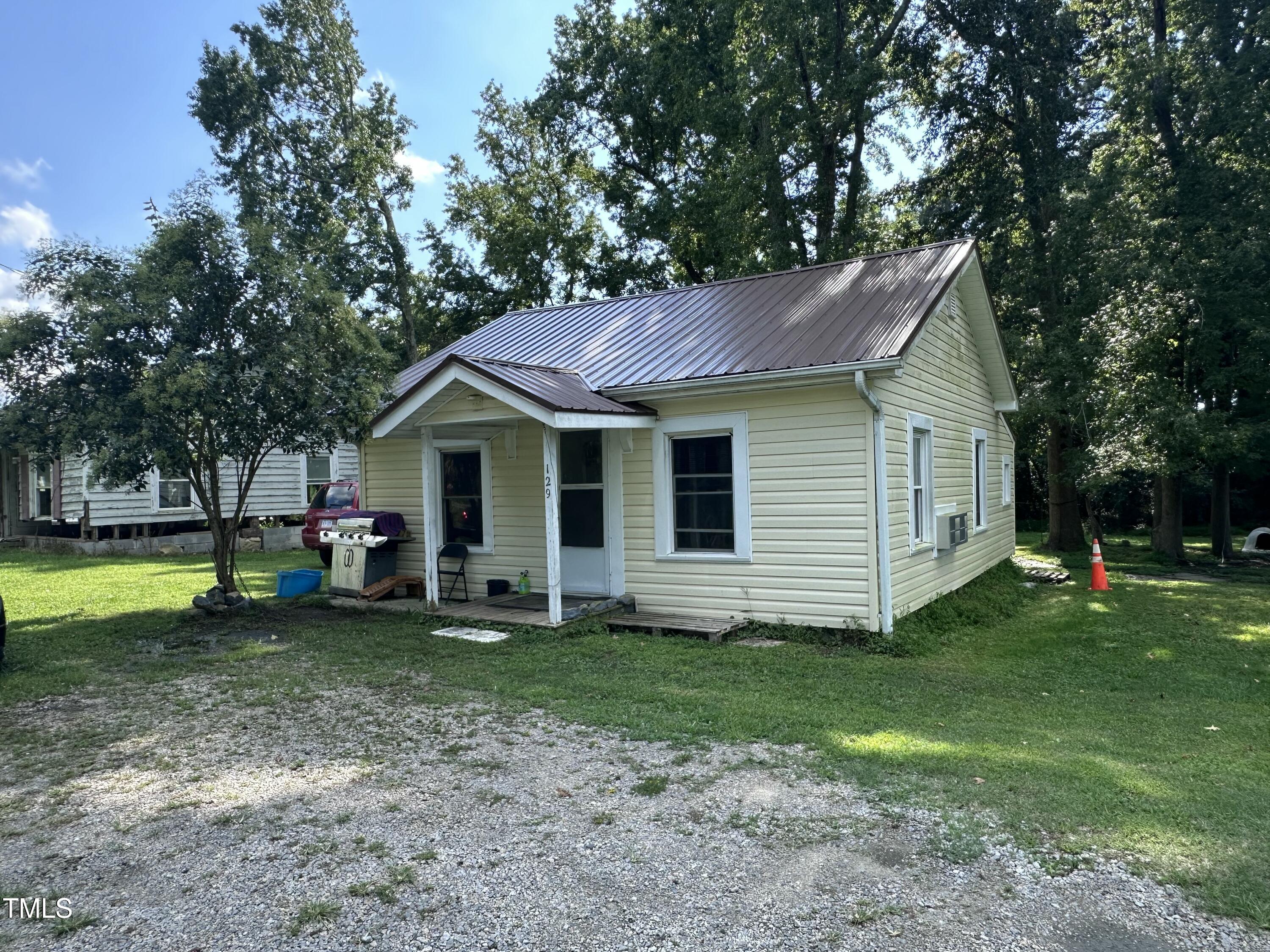 a front view of a house with a garden and trees