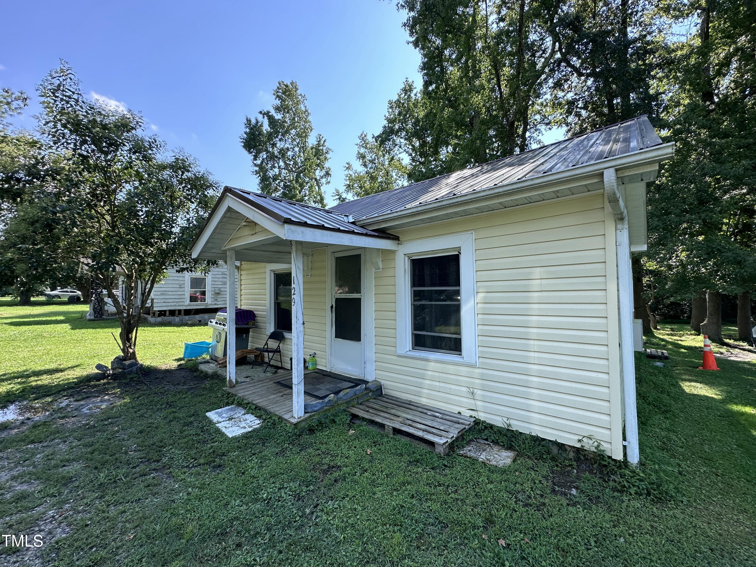 129 Spring Valley Road Henderson, NC 27536 - Photo 11 of 14 a view of a house with a backyard and a large tree