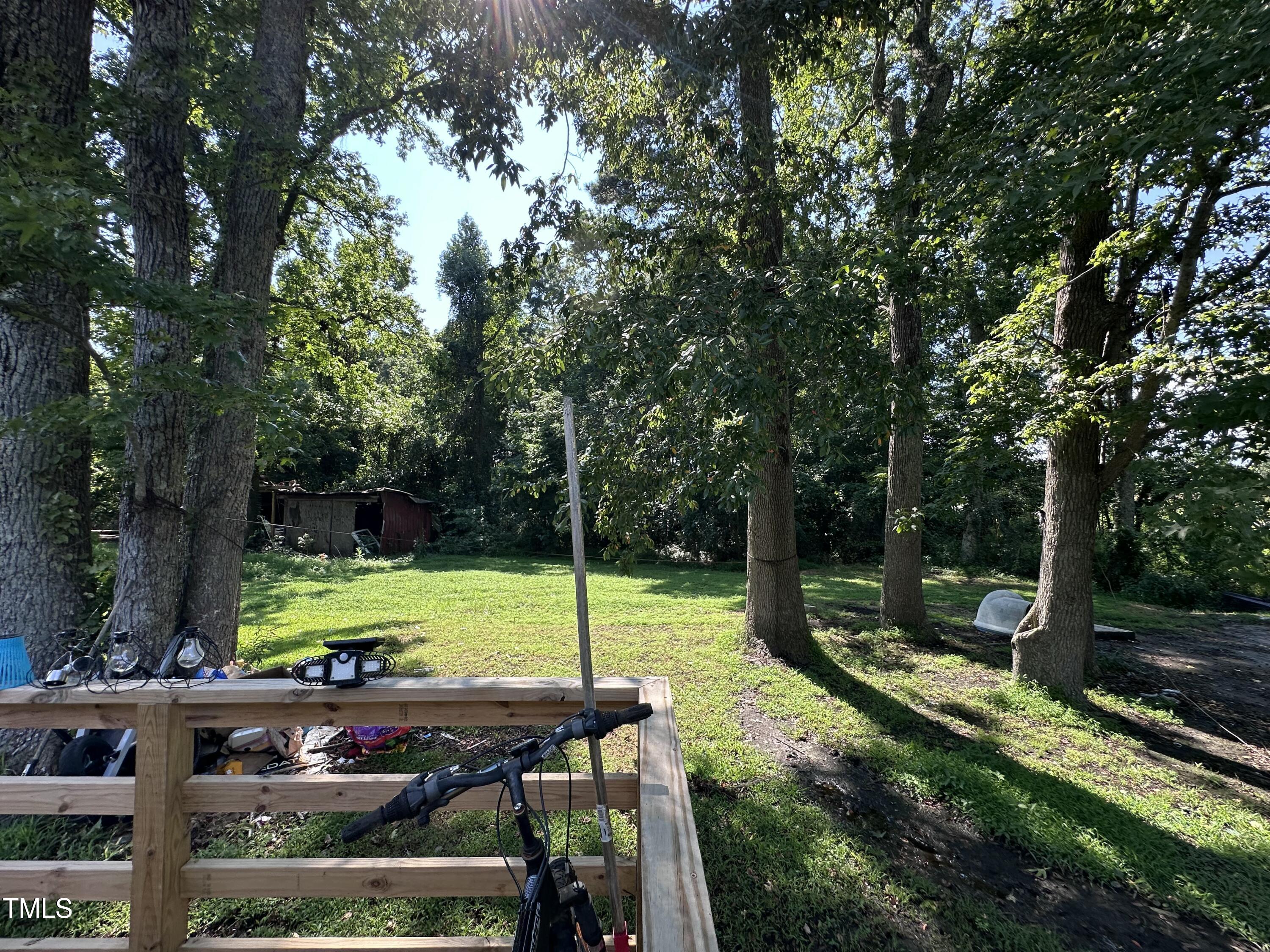 129 Spring Valley Road Henderson, NC 27536 - Photo 8 of 14 a view of a wooden deck with chairs and a yard