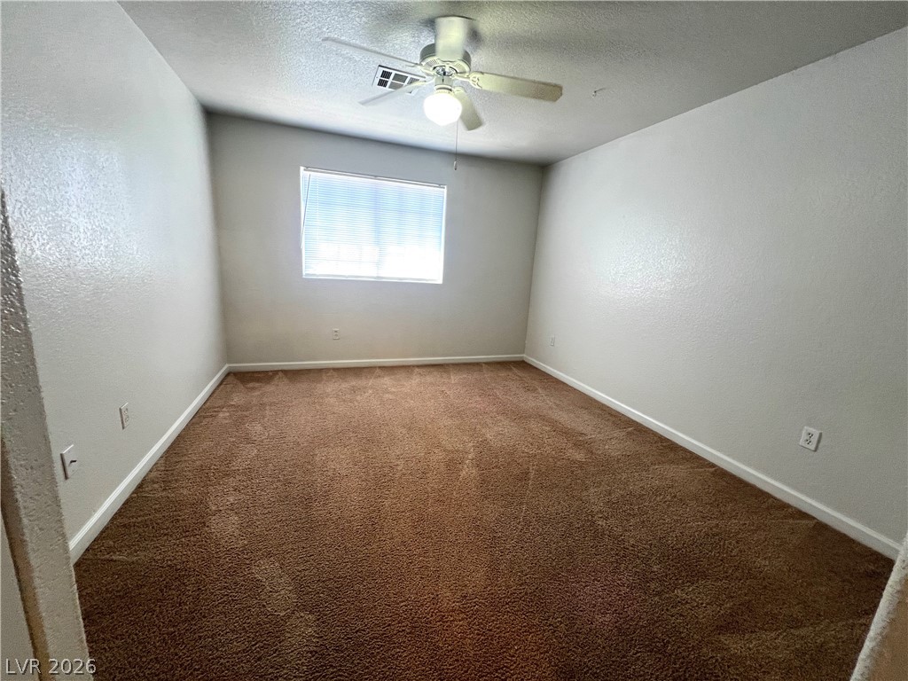 4730 East Craig Road, Unit 2104 Las Vegas, NV 89115 - Photo 13 of 20 Well-lit room with plush carpeting and a modern ceiling fan for comfort.