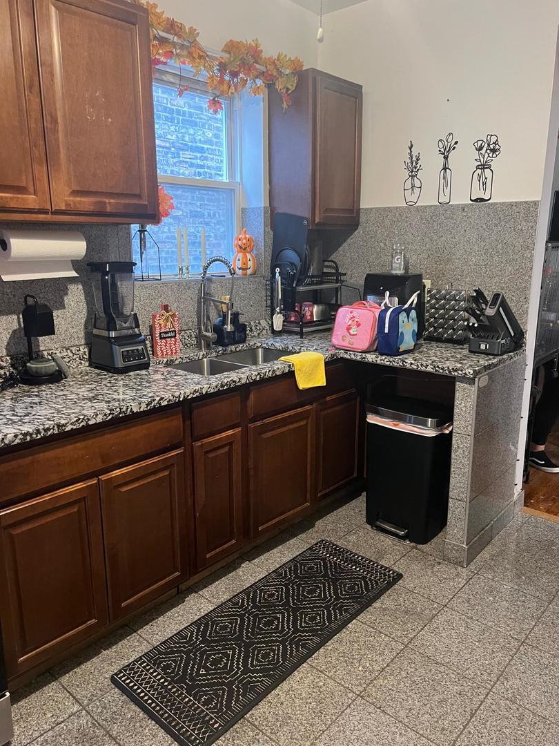 6155 South Whipple Street Chicago, IL 60629 - Photo 5 of 18 a kitchen with granite countertop a sink stove and cabinets