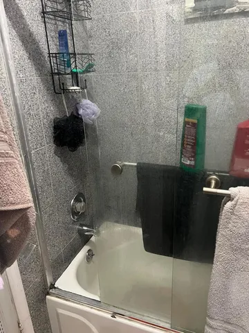 a bath tub sitting next to a bathroom sink