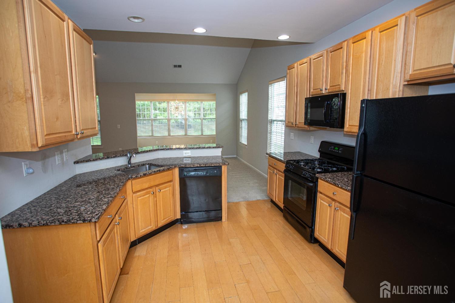 247 Spring Meadow Way Monroe Township, NJ 08831 - Photo 6 of 32 a kitchen with stainless steel appliances granite countertop a stove a sink and a refrigerator