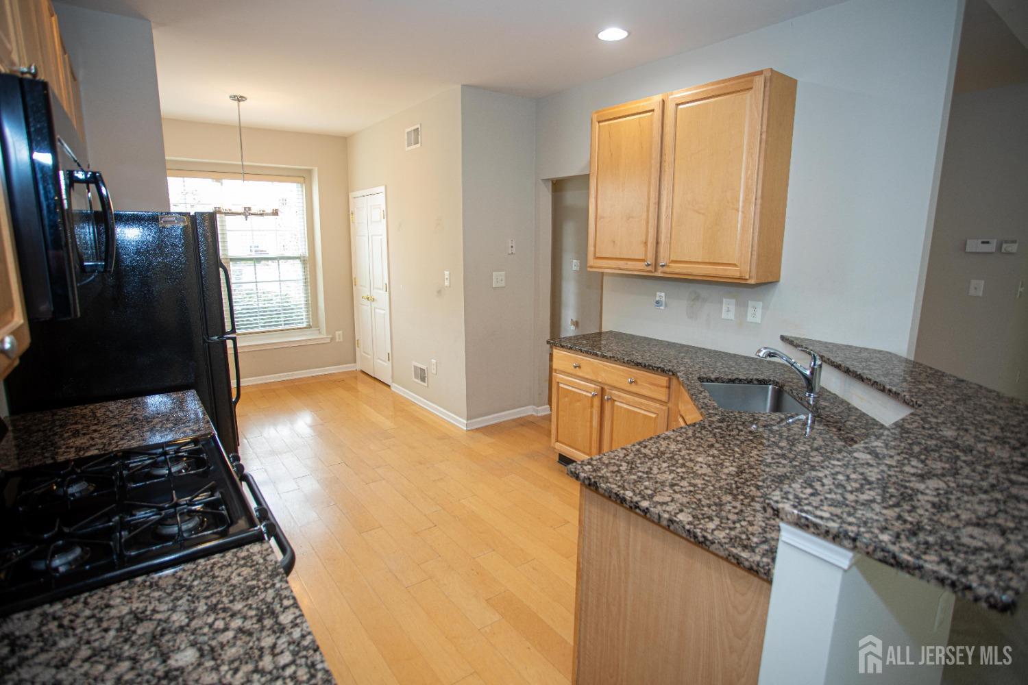 247 Spring Meadow Way Monroe Township, NJ 08831 - Photo 7 of 32 a kitchen with stainless steel appliances granite countertop a sink stove and refrigerator