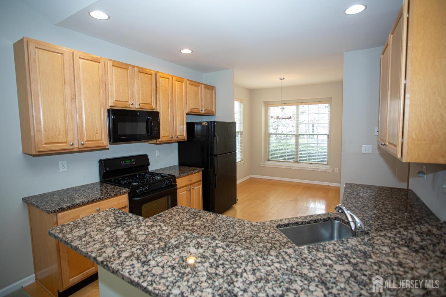 247 Spring Meadow Way Monroe Township, NJ 08831 - Photo 8 of 32 a kitchen with a sink appliances and cabinets