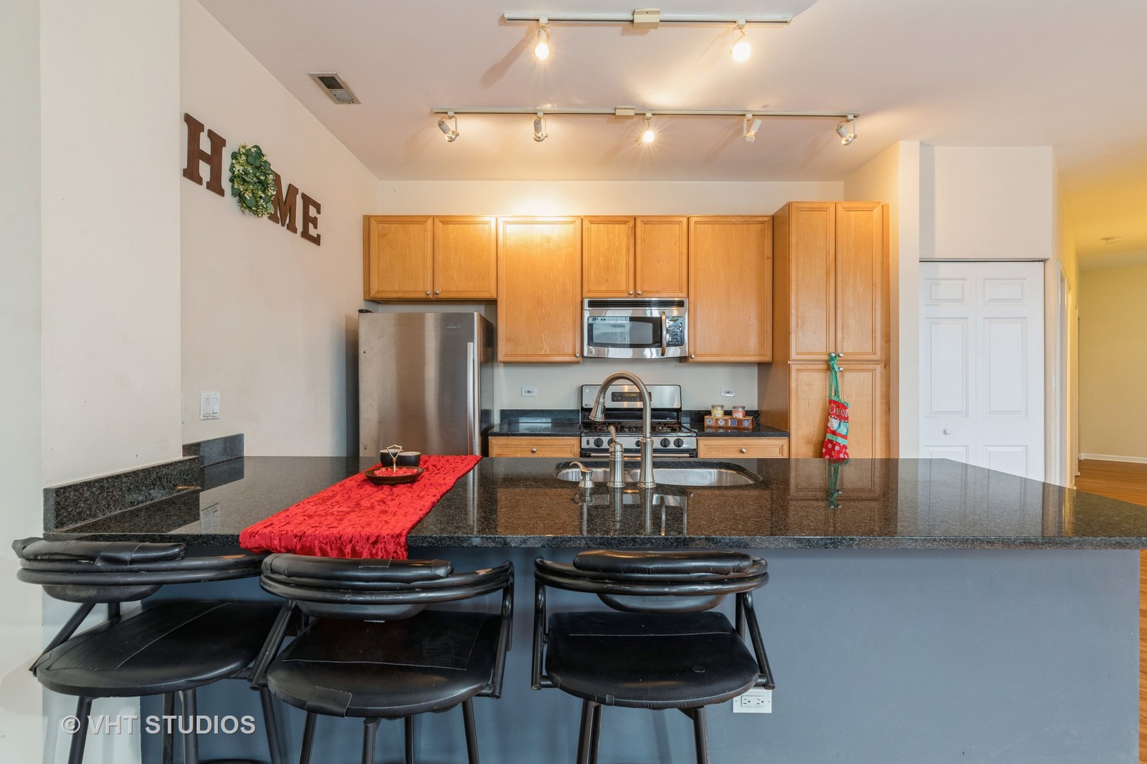 1500 South Halsted Street, Unit 3B Chicago, IL 60607 - Photo 13 of 33 a kitchen with stainless steel appliances kitchen island granite countertop a sink dishwasher a stove a refrigerator and island with wooden floor