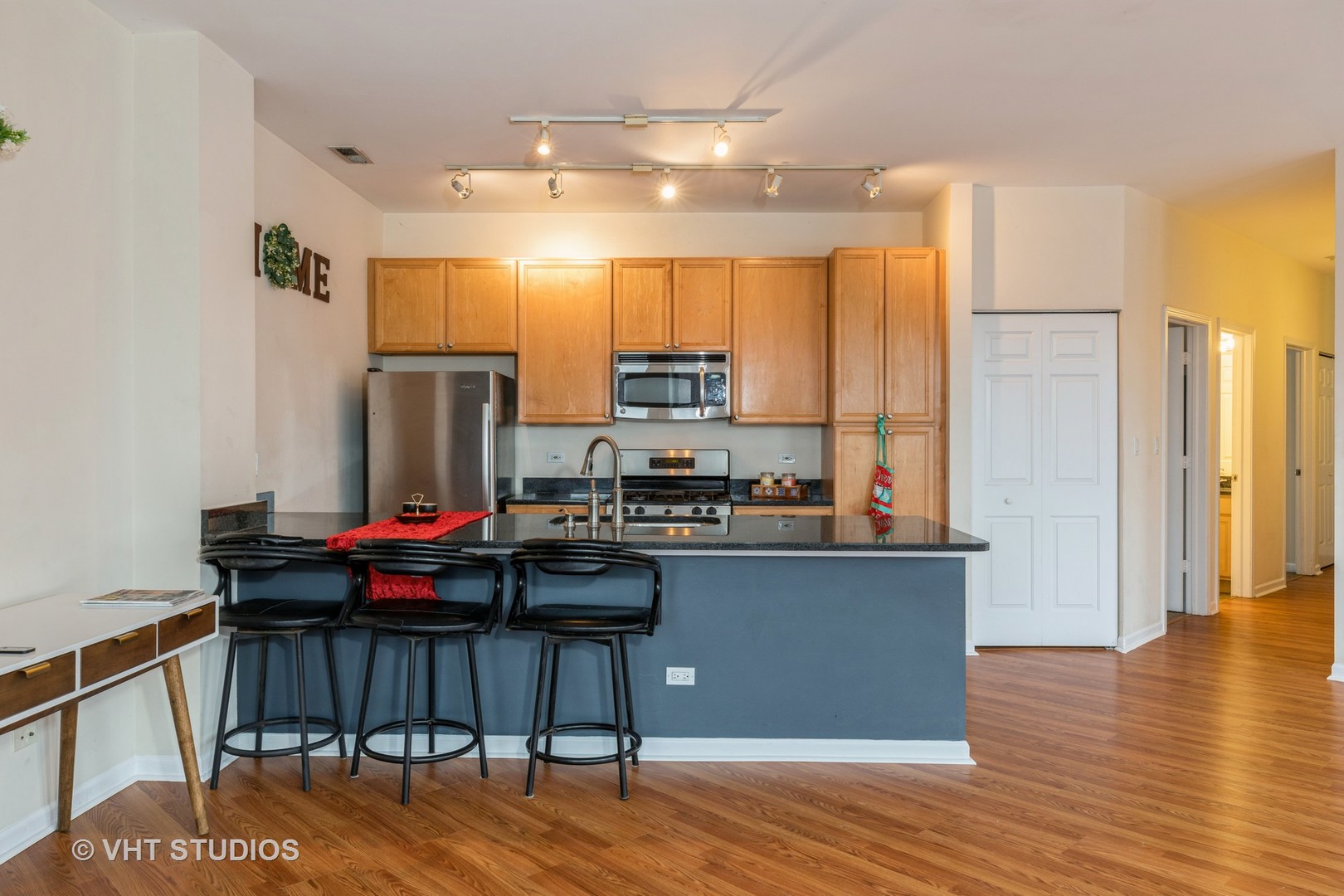 1500 South Halsted Street, Unit 3B Chicago, IL 60607 - Photo 15 of 33 a kitchen with stainless steel appliances a stove a refrigerator a sink dishwasher and a dining table with wooden floor