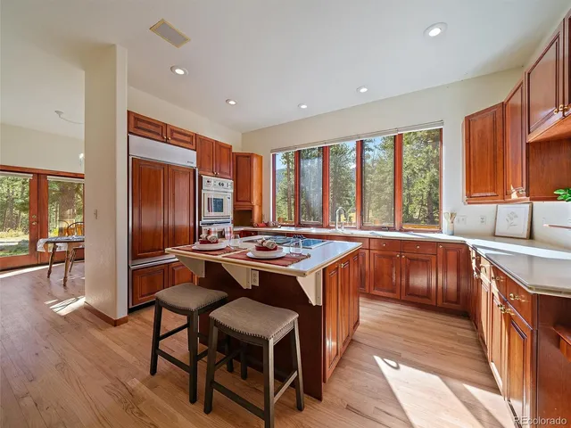 a living room with stainless steel appliances granite countertop a sink and a stove