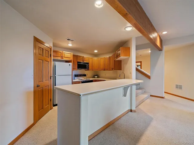 a kitchen with stainless steel appliances kitchen island a refrigerator sink and cabinets
