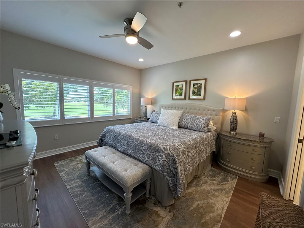 9113 Michael Circle, Unit 7710 Naples, FL 34113 - Photo 12 of 34 a spacious bedroom with a bed a window and a chandelier