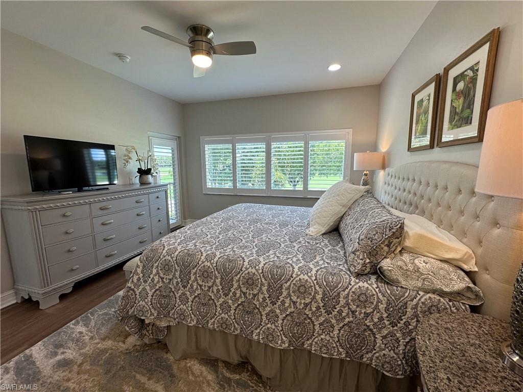 9113 Michael Circle, Unit 7710 Naples, FL 34113 - Photo 14 of 34 a bedroom with a large bed a flat tv screen and a dresser