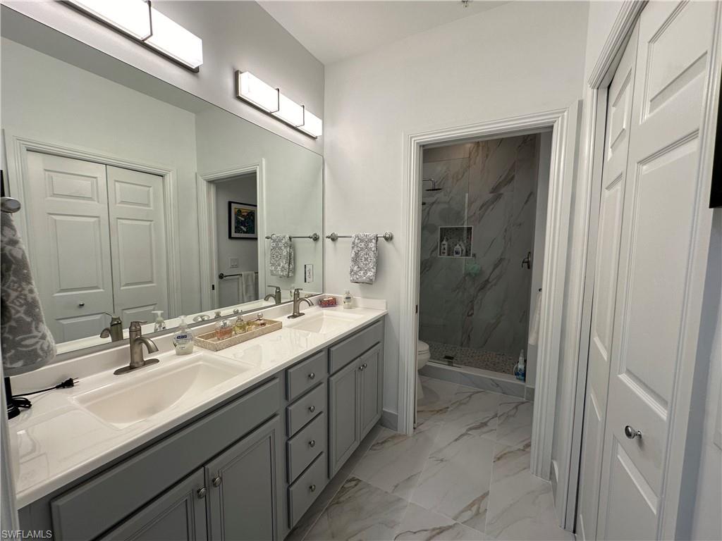 9113 Michael Circle, Unit 7710 Naples, FL 34113 - Photo 15 of 34 a bathroom with a double vanity sink mirror and shower
