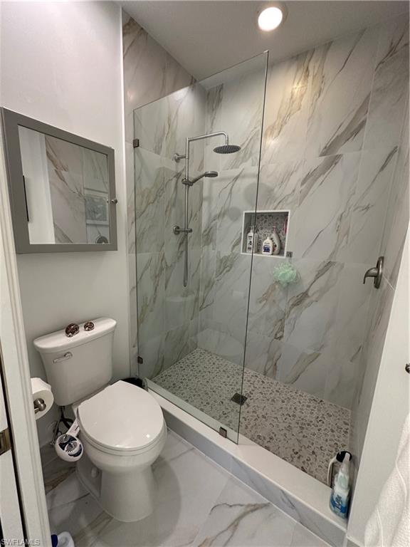 9113 Michael Circle, Unit 7710 Naples, FL 34113 - Photo 16 of 34 a bathroom with a toilet and shower