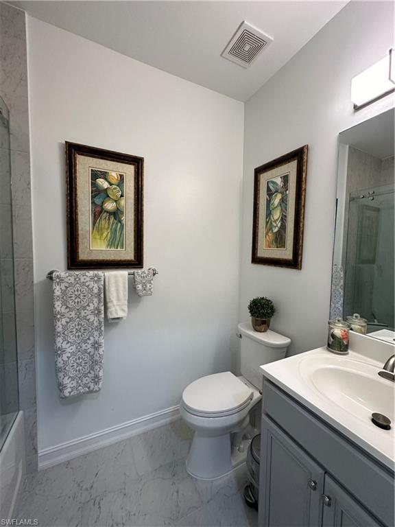 9113 Michael Circle, Unit 7710 Naples, FL 34113 - Photo 19 of 34 a bathroom with a toilet sink and mirror