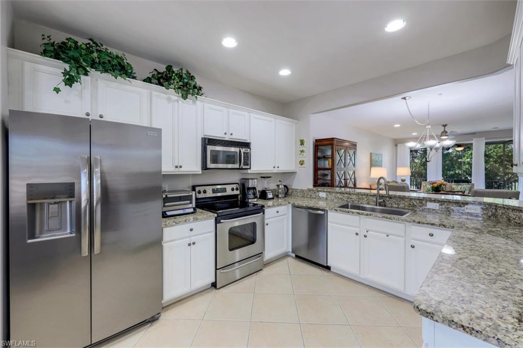 9113 Michael Circle, Unit 7710 Naples, FL 34113 - Photo 6 of 34 a modern kitchen with stainless steel appliances granite countertop a refrigerator sink and stove